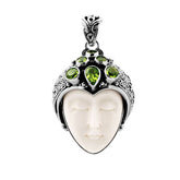 Sterling silver pendant with hand-carved bone face and sparkling peridot gemstones, unique Bali artisan jewelry.